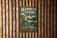 A vintage-style metal sign for Mammoth Spring State Park in Arkansas, featuring a scenic illustration of a waterfall and a building.