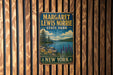 A vintage metal sign for Margaret Lewis Norrie State Park in New York, featuring a scenic landscape with a lake, mountains, and pine trees.