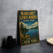A vintage metal sign for Margaret Lewis Norrie State Park in New York, featuring a scenic landscape with a lake, mountains, and flowers.