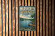 A vintage metal sign for Marsh Creek State Park in Pennsylvania, featuring a scenic image of a lake and a boat, mounted on a wooden wall.