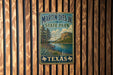 A vintage-style metal sign for Martin Dies Jr. State Park in Texas, featuring a scenic landscape with a river and mountains.