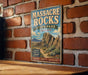 A vintage metal sign for Massacre Rocks State Park in Idaho, featuring a scenic illustration of the park's landscape.