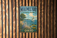 A vintage metal sign for Maumee Bay State Park in Ohio, featuring a scenic illustration of a lake, sailboat, and wildlife.