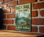 A vintage-style metal sign for Max V. Shaul State Park in New York, featuring a scenic landscape with a lake and mountains.