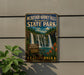 A metal sign for McCarthy Burney Falls Memorial State Park, featuring a scenic image of the waterfall and surrounding landscape.