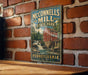 A vintage metal sign for McConnells Mill State Park in Pennsylvania, featuring a red brick wall and a waterfall in the background.