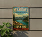 A vintage metal sign for McCroskey State Park in Idaho, featuring a scenic landscape with mountains, pine trees, and a lake.