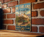 A vintage-style metal sign for McFarland State Historic Park in Arizona, featuring an illustration of a house and a horse-drawn carriage.