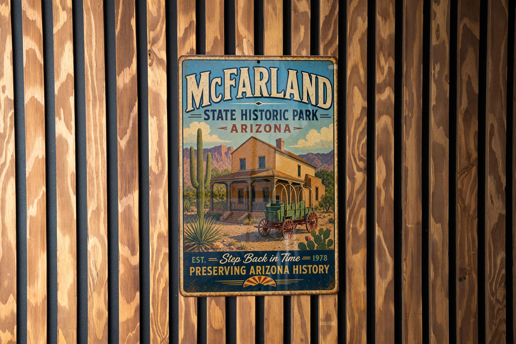 A vintage-style metal sign for McFarland State Historic Park in Arizona, featuring a desert landscape with a house and a horse-drawn carriage.