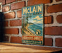 A vintage-style metal sign for Michigan State Park hangs on a brick wall, featuring a scenic image of a beach and mountains.