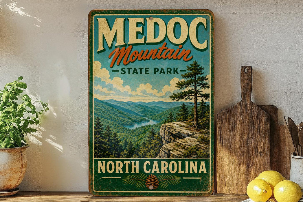 A vintage-style metal sign for Medoc Mountain State Park in North Carolina, featuring a scenic mountain landscape with pine trees and a river.