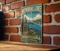 A vintage metal sign for Memorial Lake State Park in Pennsylvania, featuring a scenic illustration of the park's lake and surrounding landscape.