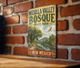 A vintage metal sign for Mesilla Valley Bosque State Park in New Mexico, featuring a scenic landscape with a river and mountains.