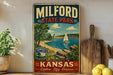 A vintage-style metal sign for Milford State Park in Kansas, featuring a scenic image of a sailboat on a lake surrounded by trees and mountains.