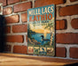 A vintage-style metal sign for Mille Lacs, Kathleen, and Montana State Park, featuring a scenic illustration of a lake, trees, and wildlife.