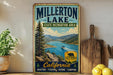 A vintage-style metal sign for Millerton Lake, California, featuring a scenic image of the lake surrounded by mountains and a boat on the water.