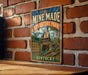 A vintage-style metal sign for the Mine Made Adventure Park in Kentucky, featuring an illustration of a person climbing a rope tower.