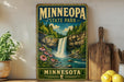A vintage-style sign for Minnesota State Park, featuring a waterfall surrounded by pine trees and flowers, with a wooden paddle and a potted plant in the foreground.