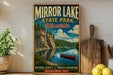 A vintage-style sign for Mirror Lake State Park in Wisconsin, featuring a scenic image of a lake with a canoe, surrounded by trees and mountains.