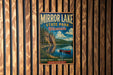 A vintage-style metal sign for Mirror Lake State Park in Wisconsin, featuring a scenic landscape with a lake, mountains, and a red canoe.