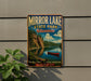A vintage-style metal sign for Mirror Lake State Park in Wisconsin, featuring a scenic landscape with a lake, mountains, and a canoe.