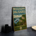 A vintage-style sign for Mississippi Palisades State Park in Illinois, featuring a scenic landscape with a river, cliffs, and a boat.