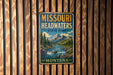 A vintage-style metal sign for Missouri Headwaters State Park, featuring a scenic landscape with a river, mountains, and pine trees.