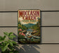 A vintage-style metal sign for Moccasin Creek State Park in Georgia, featuring a scenic illustration of a waterfall and forest.