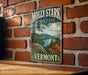 A vintage-style metal sign for Molly Stark State Park in Vermont, featuring a scenic landscape with mountains, trees, and a lake.