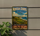 A vintage-style metal sign for Montauk Downs State Park in New York, featuring a scenic coastal landscape with a golf course and ocean in the background.