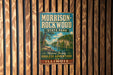 A vintage metal sign for Morrison-Rockwood State Park in Illinois, featuring a scenic landscape with a river and cliffs.