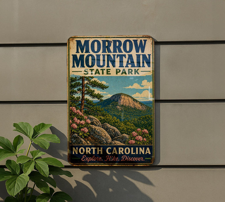 A vintage metal sign for Morrow Mountain State Park in North Carolina, featuring a scenic landscape with mountains, trees, and flowers.
