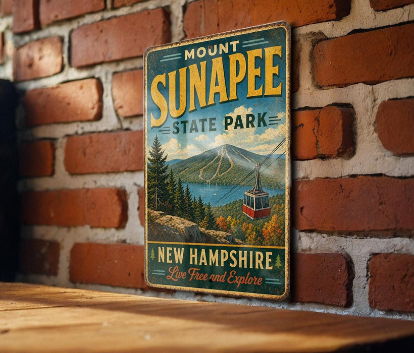 A vintage-style metal sign for Mount Sunapee State Park in New Hampshire, featuring a scenic landscape with a ski lift and mountains in the background.