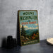 A vintage metal sign for Mount Washington State Forest in Massachusetts, featuring a scenic mountain landscape.