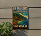 A vintage-style metal sign for the Na Pali Coast Wilderness Park in Hawaii, featuring a mountainous landscape with a beach and ocean.