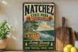 A vintage-style sign for Natchez State Park, Mississippi, featuring a scenic landscape with a river, cliffs, and trees.