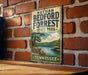 A vintage-style metal sign for Nathan Bedford Forrest State Park in Tennessee, featuring a scenic landscape with a lake and mountains.