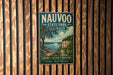 A vintage metal sign for Nauvoo State Park in Illinois, featuring a scenic landscape with a river and cliffs.