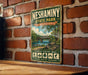 A vintage-style metal sign for Neshaminy State Park in Pennsylvania, featuring an illustration of a bridge and a scenic landscape.