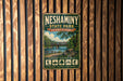 A vintage-style metal sign for Neshaminy State Park in Pennsylvania, featuring a scenic illustration of a bridge over a river surrounded by trees.