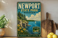 A vintage-style metal sign for Newport State Park in Wisconsin, featuring a scenic landscape with a lake, cliffs, and a sailboat.