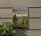 a vintage-style metal sign that reads "Welcome to Newton Hills State Park" with a scenic landscape of mountains, trees, and a lake below.