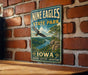 A vintage-style metal sign for Nine Eagles State Park in Iowa, featuring an eagle in flight and a scenic landscape.