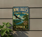 A vintage-style metal sign for Nine Eagles State Park in Iowa, featuring an eagle in flight and a scenic landscape.