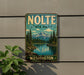 A vintage-style metal sign for Nolte State Park in Washington, featuring a scenic landscape with mountains, pine trees, and a lake.