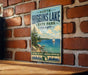 A vintage-style metal sign for North Higgins Lake State Park in Michigan, featuring a scenic image of the lake and surrounding landscape.