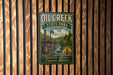 A vintage-style metal sign for Oil Creek State Park in Pennsylvania, featuring a scenic illustration of a river, a mill, and a forest.
