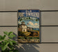 A vintage-style metal sign for Fort Townsend State Park in Washington, featuring a white building with a tower, a cannon, and a sailboat in the background.