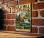A vintage-style metal sign for Old Mill State Park in Minnesota, featuring a scenic illustration of a waterfall and a building.