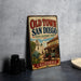 A vintage-style metal sign for Old Town San Diego, featuring an illustration of a historical building and a wagon, with the text "Old Town San Diego State Historic Park" and "California" at the bottom.